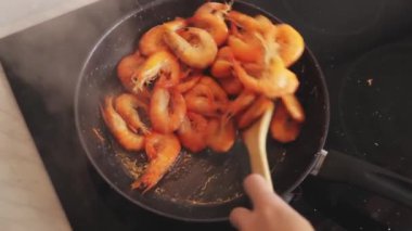 Şef tavada yemek pişiriyor.