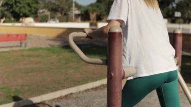 Parkta esneme egzersizleri yapan genç bir kadın.