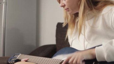 Kanepede gitar çalan kadın.