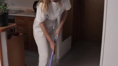 Beyaz odadaki bir kız temizlik yapıyor..