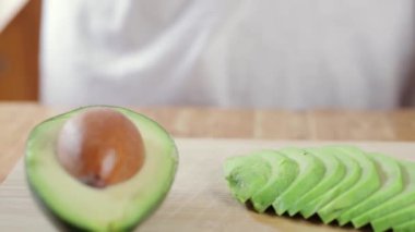 Beyaz bir tahtaya bir dilim taze avokado kes.