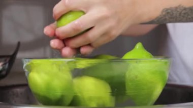 Genç bir kadın mutfakta limon suyu sıkıyor.