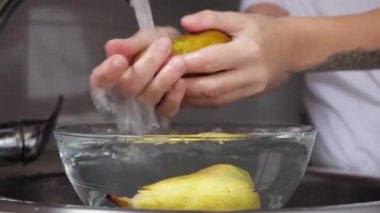 Kadın bardağa meyve suyu döküyor.