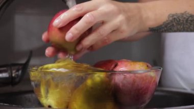 Adam bardağa elma döküyor.