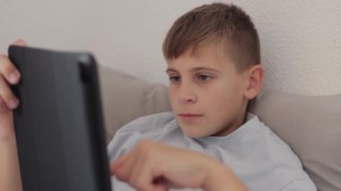 bir tablet kullanan genç çocuk