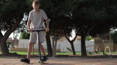 Sokakta scooter süren genç bir adam.