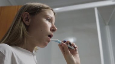 Diş teli fırçalayan genç bir kadın..