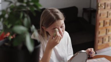 Akşamları evde akıllı telefon kullanan genç bir kadın, mutfakta bir kadın.