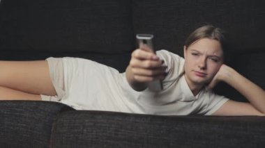 Evde televizyon izleyen bir kadın.