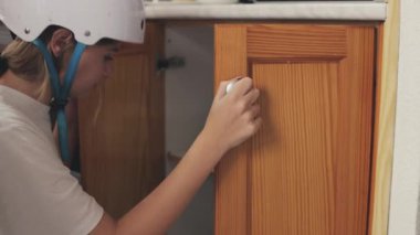 Beyaz kasklı ve üniformalı genç bayan işçi mutfakta çalışıyor.