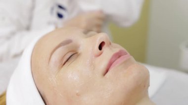 Spa salonunda kozmetik maskeli bir kadın.