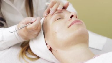 Güzellik uzmanı genç bir kadının yüzüne yüz masajı yapıyor. Kapat. yüksek kaliteli fotoğraf