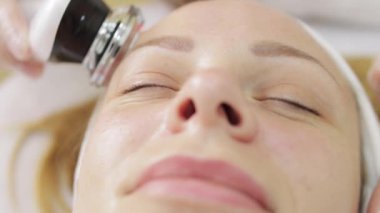 Genç bir kadın güzellik salonunda yüz bakımı yaptırıyor. Kapat.