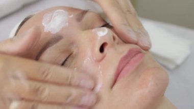 Kadın yüz masajı yaptırıyor.