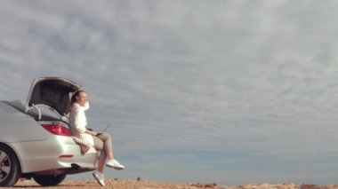 Bagajda oturan genç bir kadın.