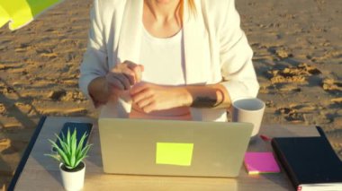 Denizde dizüstü bilgisayarı ve defteri olan kız.