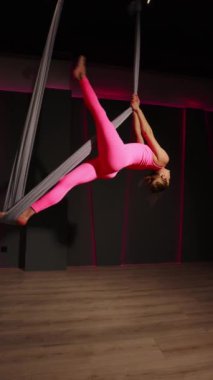 Genç kız hamakta hava yogası yapıyor.