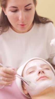 Genç bir kadın güzellik tedavisinde yüz maskesi takıyor..
