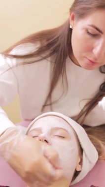Güzellik maskeli genç kadın güzellik salonunda yüz bakımı yaptırıyor..