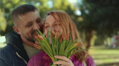 Mutlu bir çift mutlu gülümseyen adam ve laleli kadın..