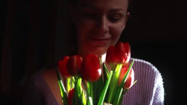 Kırmızı lale tutan bir kadın.