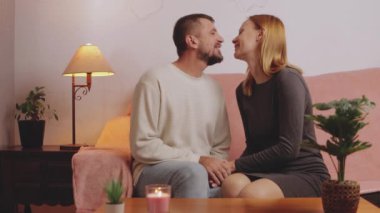 Oturma odasındaki kanepede oturan mutlu genç çift. Romantik ilişki. Aşık mutlu bir çift. Erkek ve kadın aşık..