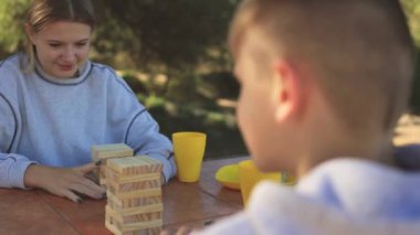 Çocuk parkta küçük kızıyla oynuyor.