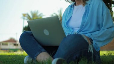 Dışarıda dizüstü bilgisayarda çalışan bir kadın.