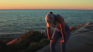 Spor kıyafetli kız esneme egzersizleri yapıyor.