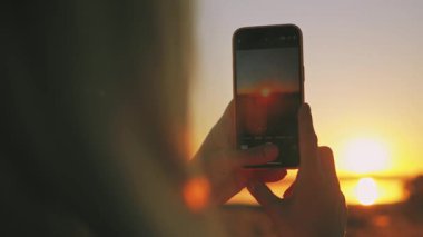 Selfie çeken bir kadının silüeti.