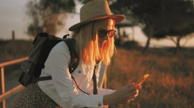 Sahada şapkalı ve sırt çantalı bir kız.