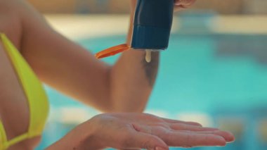 Elinde mavi su püskürten mayolu bir kadın.