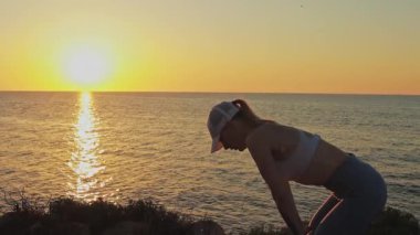 Deniz kıyısında yoga yapan güzel bir kadın..