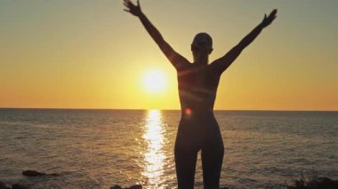 Günbatımı arka planında bikinili ve güneş gözlüklü kadın..