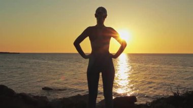 Deniz kıyısındaki bir kızın silueti.