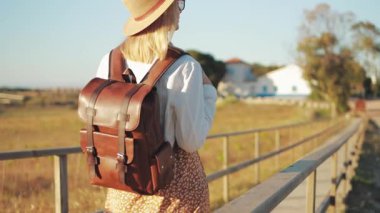 Sırt çantalı genç bir kız yolda yürüyor.