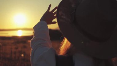 Sırt çantalı bir kadın sahada. Doğada gün batımı, seyahat ve macera kavramı