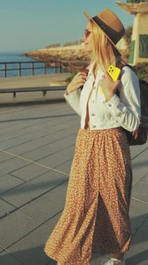 Günbatımının arka planında sırt çantası olan güzel sarışın bir kadın.