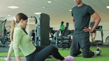 Spor salonunda egzersiz yapan genç bir çift.