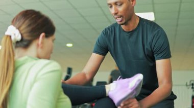 Genç kadın spor salonunda kişisel antrenör ile egzersiz