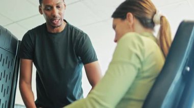 Spor kıyafetli gülümseyen genç bir kadının portresi spor salonunda kardiyo çalışması yapıyor..