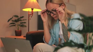 Genç sarışın kadın oturma odasında dizüstü bilgisayar kullanıyor. yüksek kaliteli fotoğraf