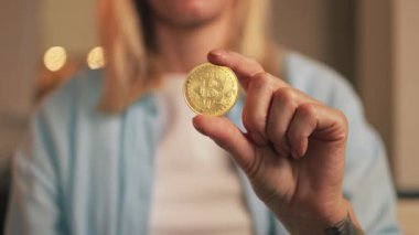 Sanal paranın önünde Bitcoin tutan kadın.