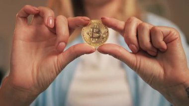 Altın Bitcoin 'i tutan kadın eli.