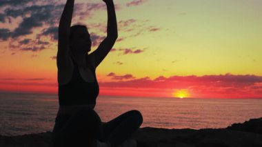 Yoga pozu. Gün batımında yoga yapan bir kız..