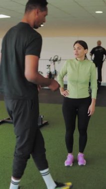 Spor salonunda kadın ve antrenör.