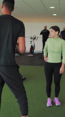 Spor salonundaki adam ve antrenör.