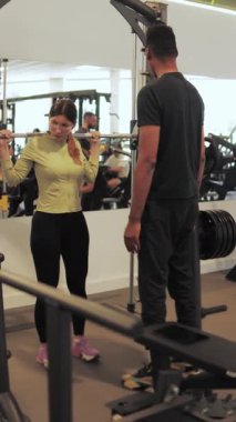 Kadın spor salonunda kişisel antrenörle kişisel antrenörlük yapıyor.