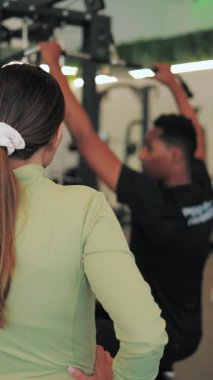 Spor salonunda egzersiz yapan genç bir kadın.