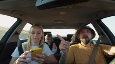 Arabalı genç bir kadın, şapkalı sakallı bir adam, cep telefonuyla konuşan bir kız ve bir erkek.